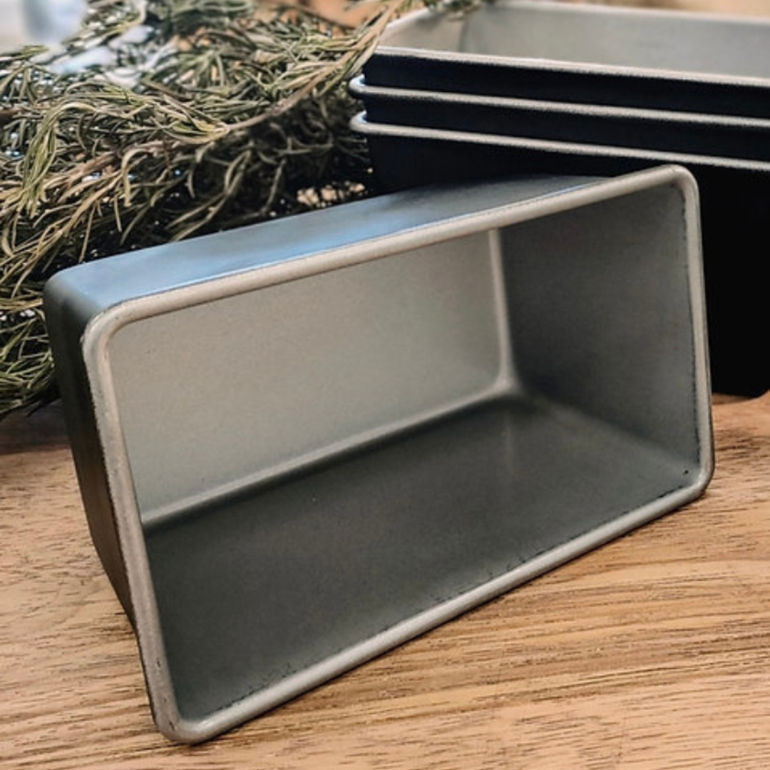 Commercial bread tin, perfect for baking OMGoodness GF/DF Organic bread, stacked in front of a bunch of dried rosemary sprigs