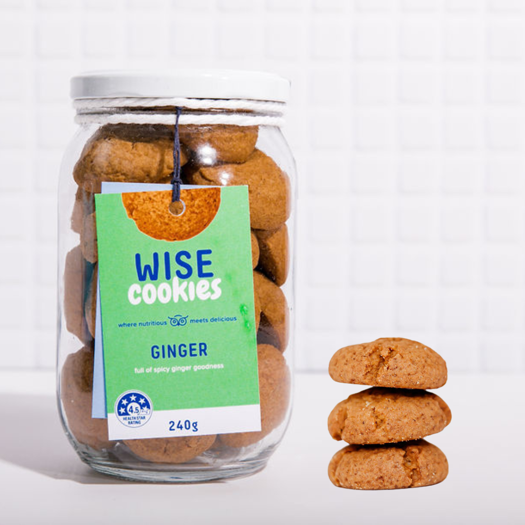 Wisefoods | 4.5 Health Star rated, allergy-friendly, plant based Ginger Wise Cookies in a glass jar with a stack of loose cookies to the right in the foreground