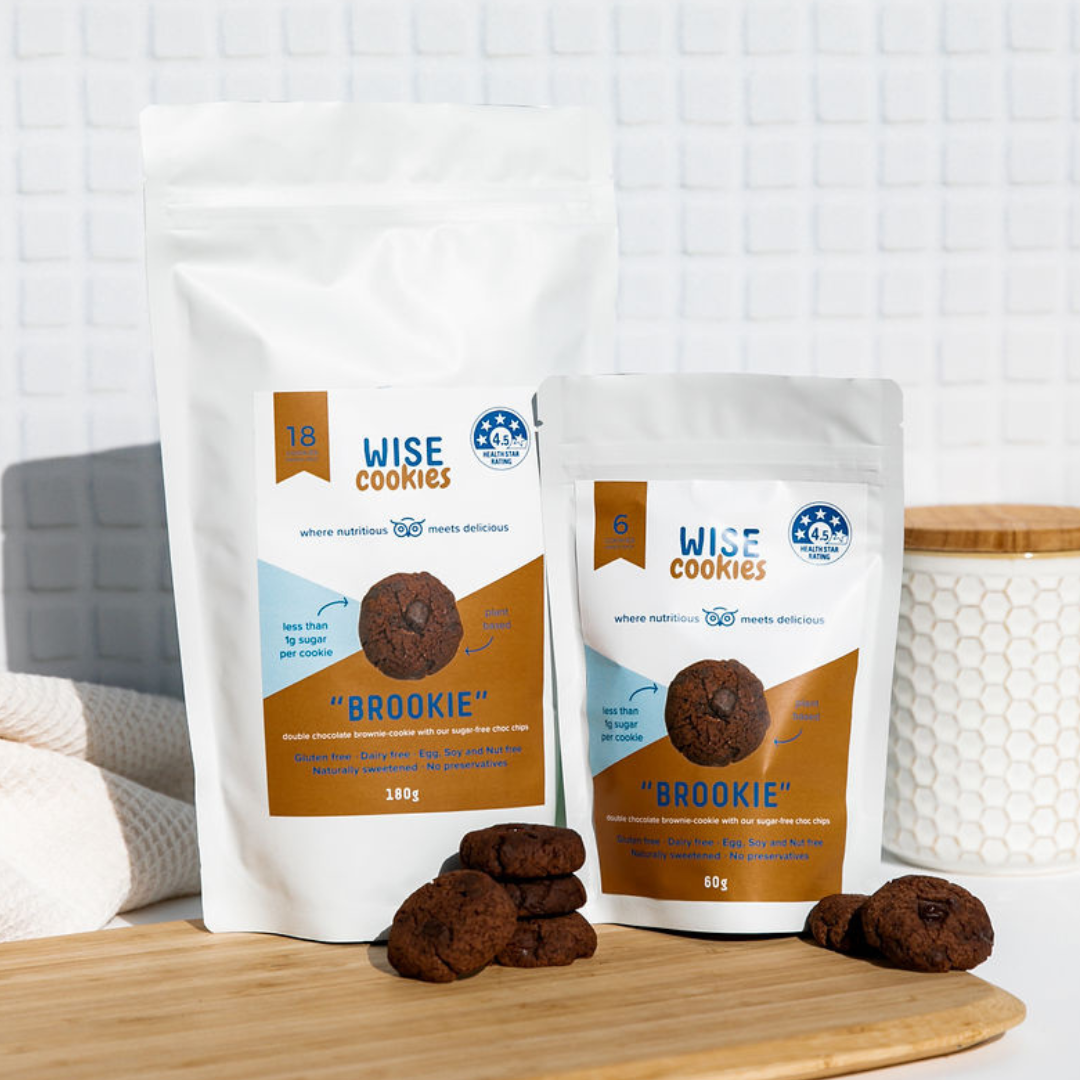 Wisefoods | 4.5 Health Star rated, allergy-friendly Double Choc &quot;Brookie&quot; Wise Cookies on bamboo board with a Pantry Pack &amp; Snack Pack in the background