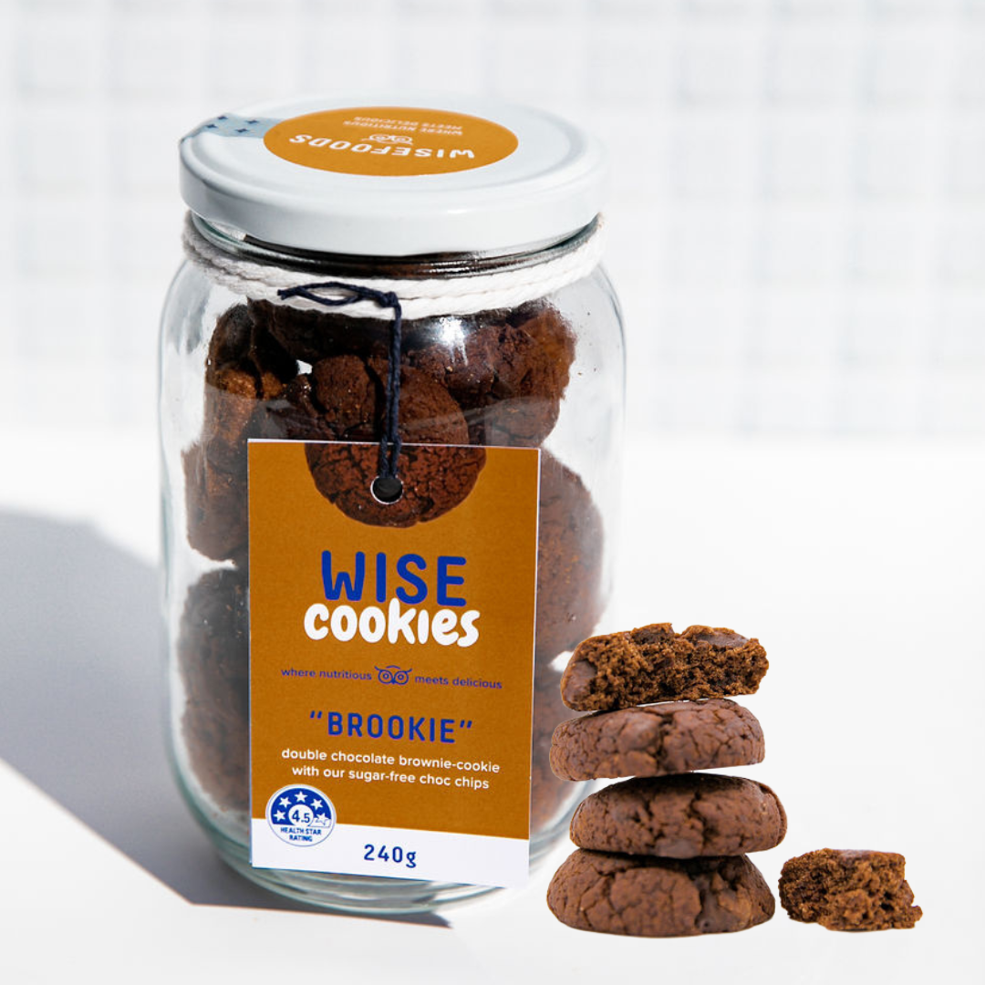 Wisefoods | 4.5 Health Star rated, allergy-friendly Double Choc &quot;Brookie&quot; Wise Cookies in a glass jar with a stack of loose cookies in the foreground