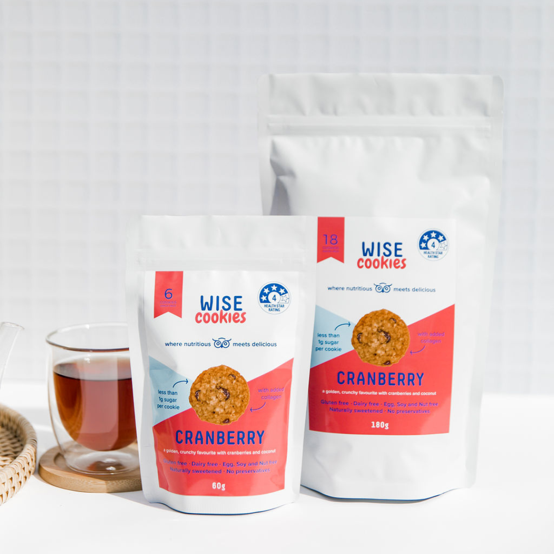 Wisefoods | Pantry Pack and Snack Pack of 4.0 Health Star rated, allergy-friendly, collagen Cranberry Wise Cookies side-by-side on a white background with a thermo-glass of black tea to the left