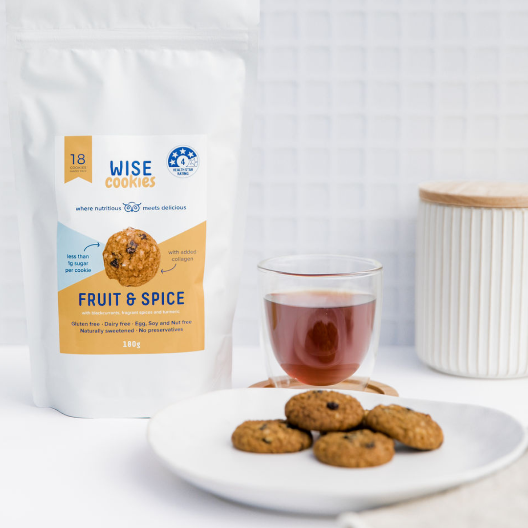 Wisefoods | Pantry Pack of 4.0 Health Star rated, allergy-friendly Fruit &amp; Spice Wise Cookies, displayed together with loose cookies on a white plate and a thermo-glass of black tea with a white ceramic jar in the background